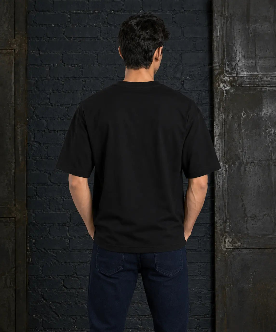 Back view of a model wearing the plain black Mood Swings oversized T-shirt.